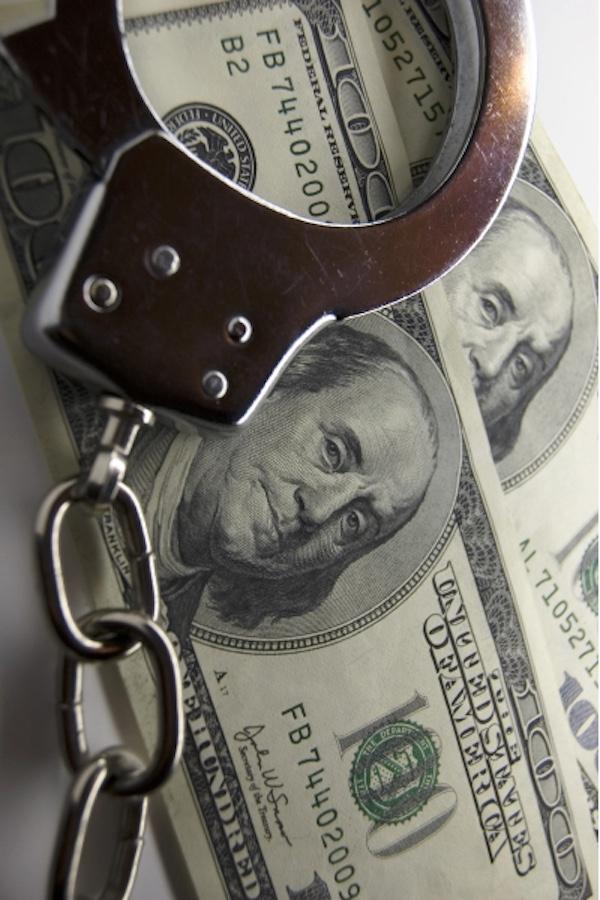 handcuffs over some dollar bills