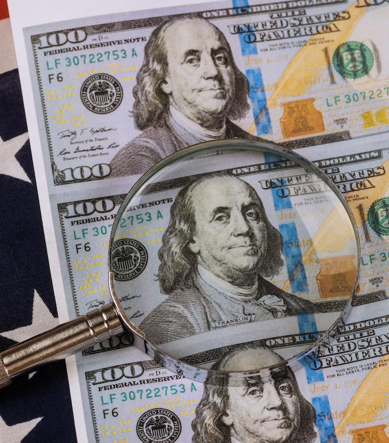 looking glass over dollar bills